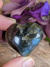 Load image into Gallery viewer, Two fingers holding a labradorite heart.