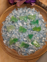 Load image into Gallery viewer, Green carved agate fish in a bowl of aquamarine chips.