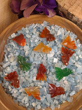 Load image into Gallery viewer, Green and orange carved agate fish in a bowl of aquamarine chips.