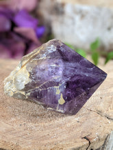 Load image into Gallery viewer, Extra small amethyst wand point laying on a wooden stump.

