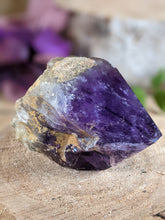 Load image into Gallery viewer, Extra small amethyst wand point laying on a wooden stump.
