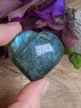 Load image into Gallery viewer, Two fingers holding a labradorite heart.
